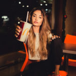 woman-holding-mcdonalds-cup-while-sitting-on-chair-1883305