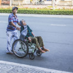 man-pushing-a-woman-sitting-on-wheelchair-3101214