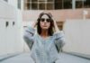 woman-in-grey-knit-shirt-standing-on-roadway-during-daytime