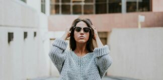 woman-in-grey-knit-shirt-standing-on-roadway-during-daytime