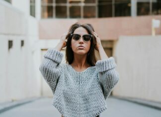 woman-in-grey-knit-shirt-standing-on-roadway-during-daytime